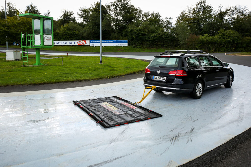 Auto mit Kehrmatte auf Straße